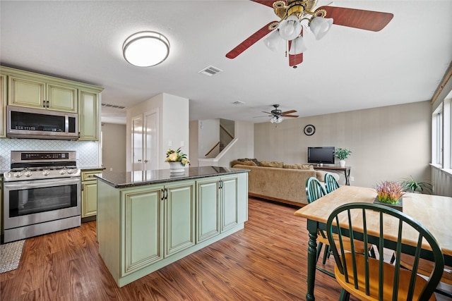 kitchen featuring decorative backsplash, a kitchen island, stainless steel appliances, and green cabinetry