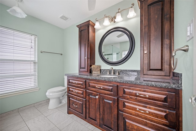 bathroom featuring tile patterned flooring, vanity, plenty of natural light, and toilet