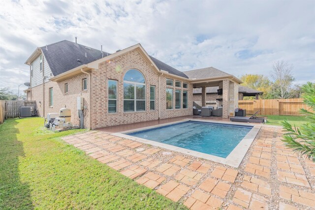 back of house featuring an outdoor living space, a fenced in pool, a yard, central AC, and a patio area