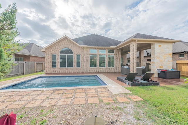 view of pool featuring a lawn, ceiling fan, a fireplace, and a patio