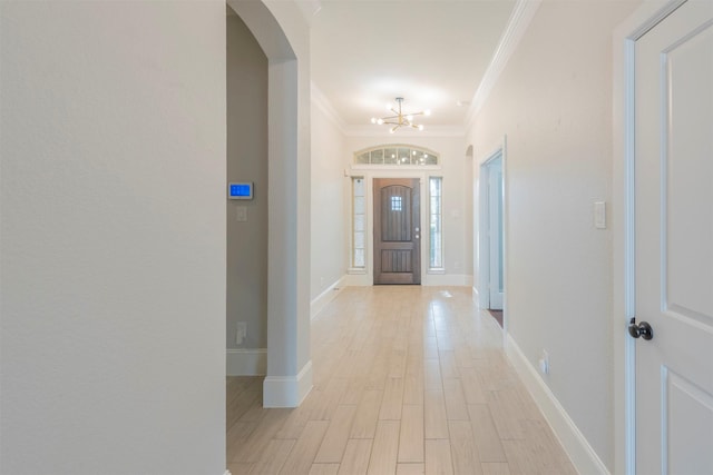 foyer entrance featuring a chandelier, light hardwood / wood-style flooring, and ornamental molding