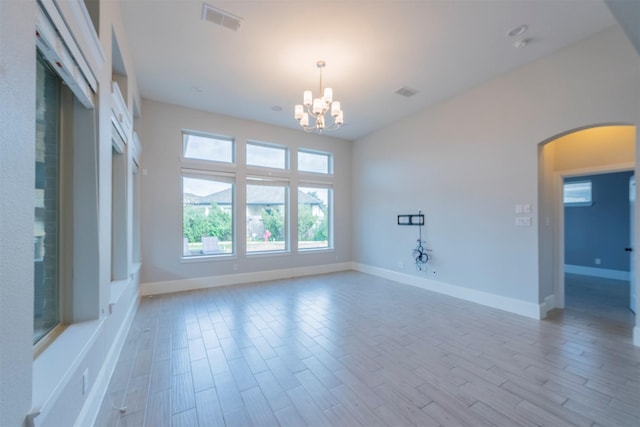 spare room featuring an inviting chandelier