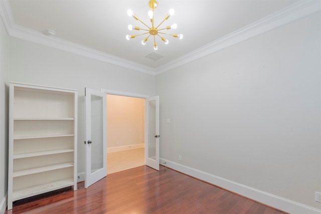 unfurnished bedroom featuring dark hardwood / wood-style flooring, french doors, crown molding, and an inviting chandelier