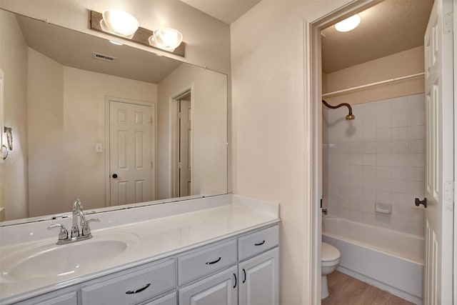 full bathroom featuring vanity, toilet, wood-type flooring, and a textured ceiling