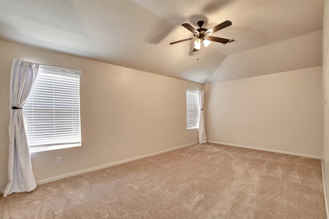 carpeted spare room featuring ceiling fan and lofted ceiling