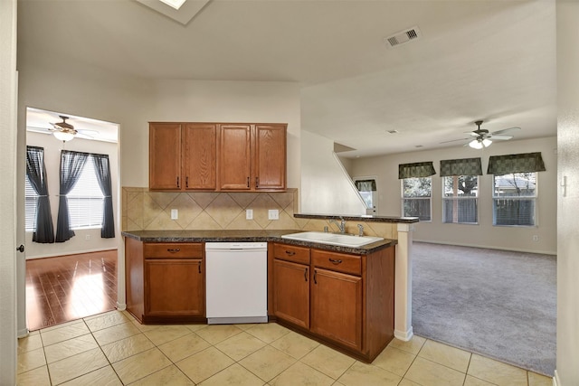 kitchen with light tile patterned flooring, white dishwasher, and sink