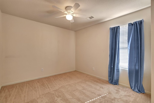 spare room featuring light carpet and ceiling fan