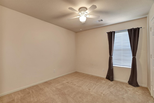 carpeted empty room featuring ceiling fan and a textured ceiling