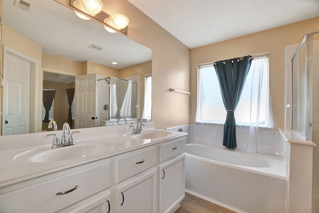 bathroom with hardwood / wood-style flooring, vanity, and independent shower and bath