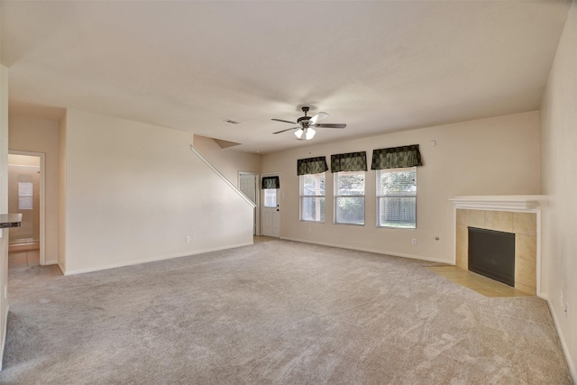 unfurnished living room featuring a fireplace, light carpet, and ceiling fan