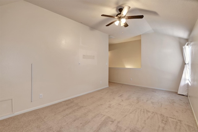 carpeted empty room featuring ceiling fan and vaulted ceiling