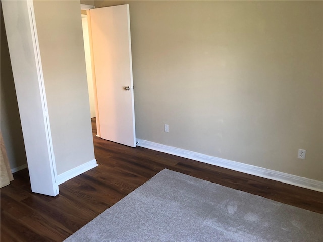 unfurnished room with dark hardwood / wood-style flooring