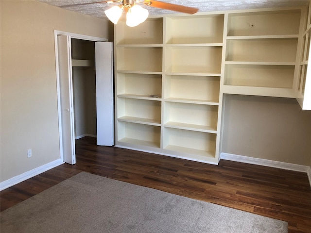 unfurnished bedroom with ceiling fan, a closet, dark wood-type flooring, and a textured ceiling