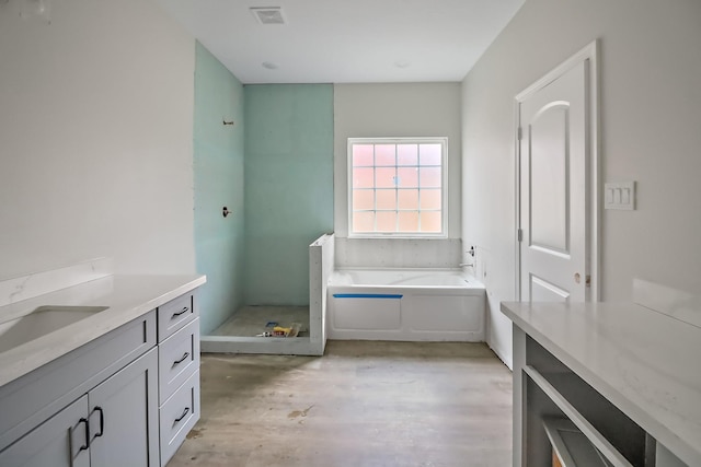 bathroom with vanity, wood-type flooring, and a bath