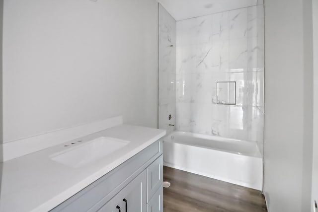 bathroom featuring vanity, tiled shower / bath combo, and hardwood / wood-style flooring