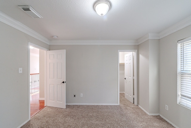 carpeted spare room with a textured ceiling and ornamental molding