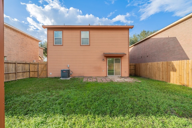 back of property with a lawn, central air condition unit, and a patio area