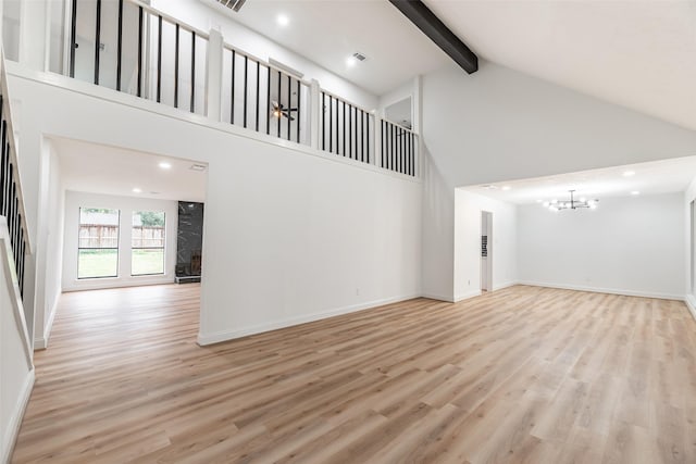 unfurnished living room with light hardwood / wood-style flooring, high vaulted ceiling, beamed ceiling, and an inviting chandelier