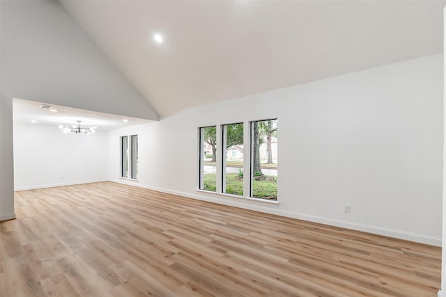 unfurnished room with light hardwood / wood-style floors, high vaulted ceiling, and a notable chandelier