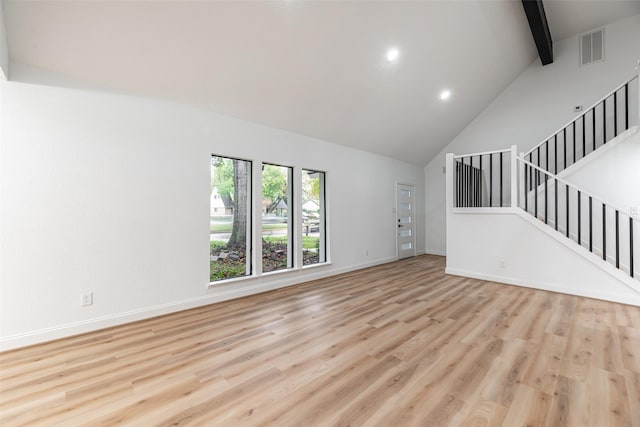 unfurnished living room with beamed ceiling, light hardwood / wood-style floors, and high vaulted ceiling