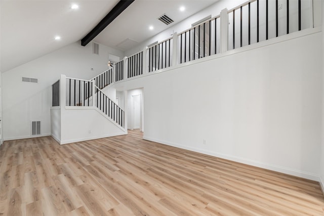 unfurnished living room featuring beamed ceiling, high vaulted ceiling, and light hardwood / wood-style flooring