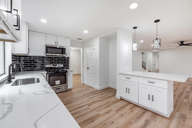 kitchen featuring white cabinets, light wood-type flooring, and stainless steel appliances