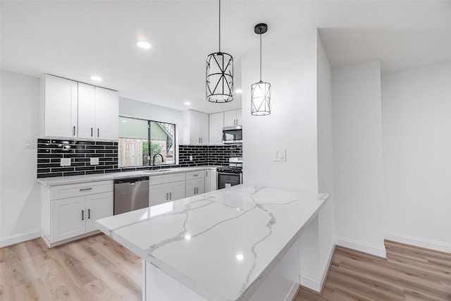 kitchen featuring white cabinets, pendant lighting, kitchen peninsula, and stainless steel appliances