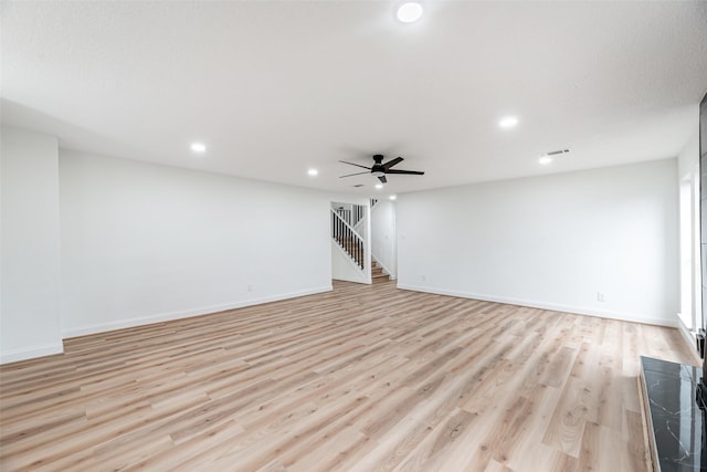 unfurnished living room with light wood-type flooring and ceiling fan