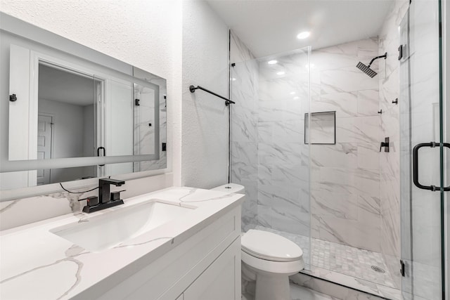 bathroom with vanity, toilet, and a shower with door