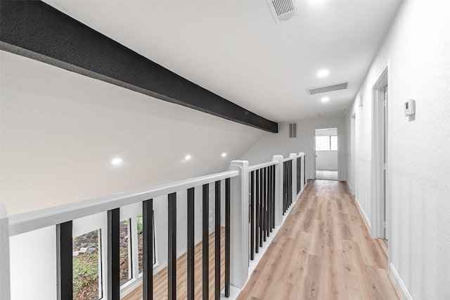 hallway with vaulted ceiling with beams and light wood-type flooring