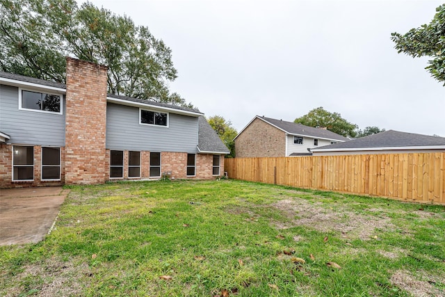 rear view of property with a lawn