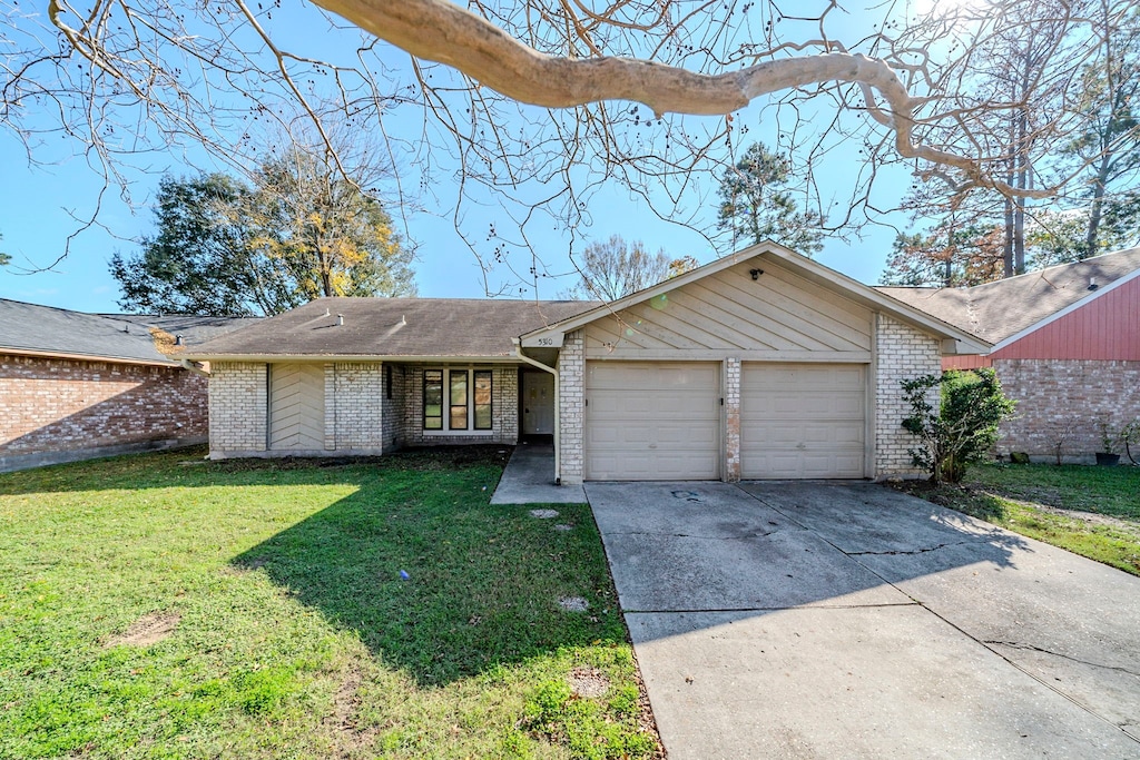 ranch-style home featuring a front lawn and a garage