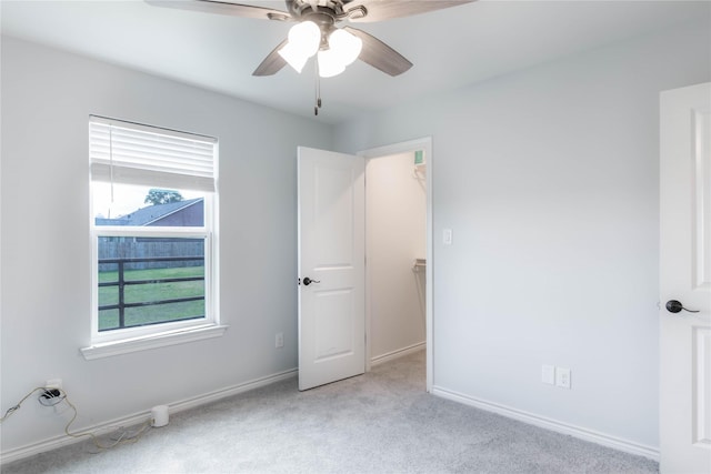 carpeted spare room featuring ceiling fan