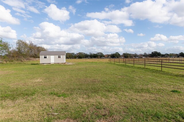 view of yard featuring a rural view and a shed