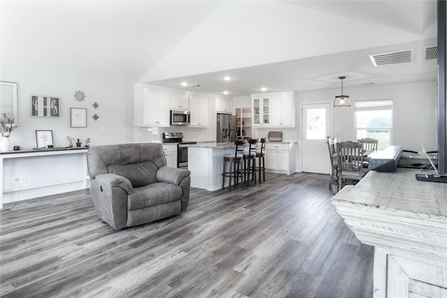 living room with hardwood / wood-style floors and vaulted ceiling