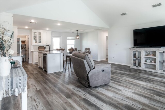 living room featuring sink, dark wood-type flooring, and vaulted ceiling