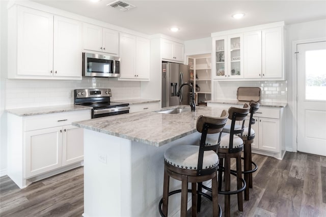 kitchen with white cabinets, sink, an island with sink, and stainless steel appliances