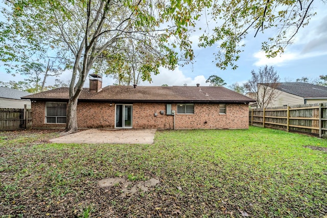 rear view of property with a lawn and a patio