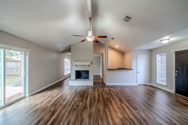 unfurnished living room with a brick fireplace, vaulted ceiling, and dark wood-type flooring