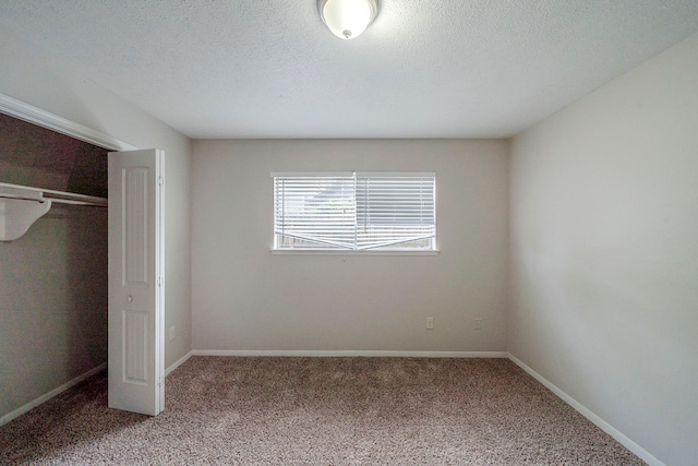 unfurnished bedroom with carpet, a textured ceiling, and a closet