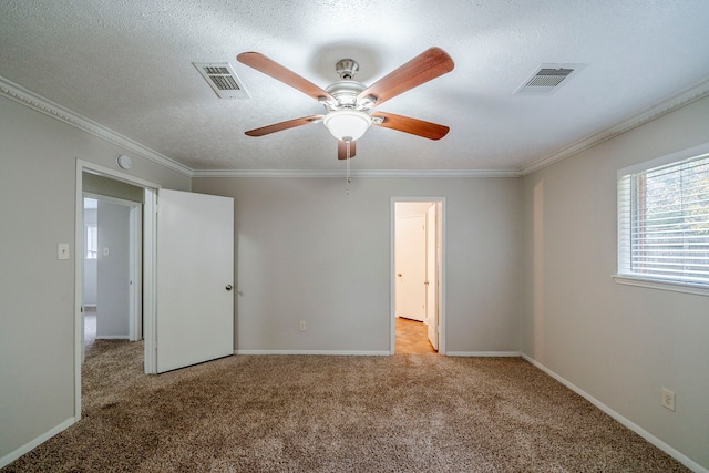 unfurnished bedroom featuring light carpet, a textured ceiling, ceiling fan, and crown molding