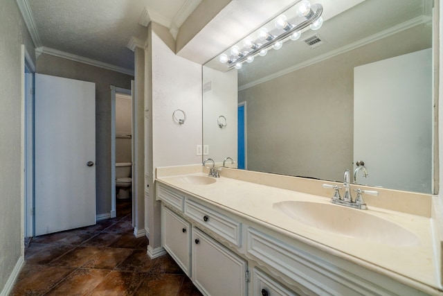 bathroom with vanity, toilet, and ornamental molding