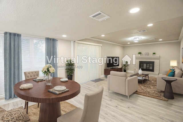 living room with crown molding, light hardwood / wood-style floors, and a textured ceiling