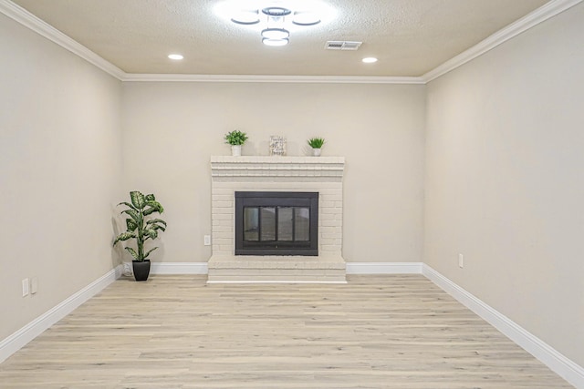 unfurnished living room featuring crown molding, a fireplace, a textured ceiling, and light wood-type flooring