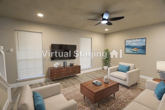 living room with ceiling fan and light wood-type flooring