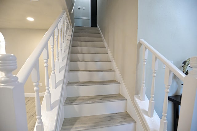 stairs featuring hardwood / wood-style floors