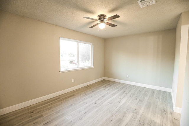 unfurnished room with ceiling fan, a textured ceiling, and light wood-type flooring