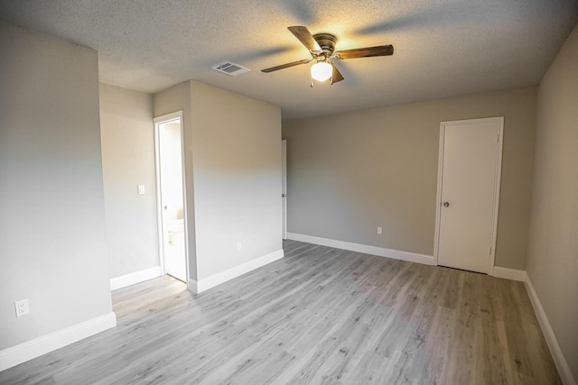 unfurnished room with ceiling fan, light hardwood / wood-style floors, and a textured ceiling