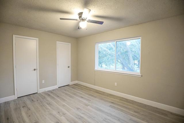 unfurnished bedroom with ceiling fan, light hardwood / wood-style floors, and a textured ceiling