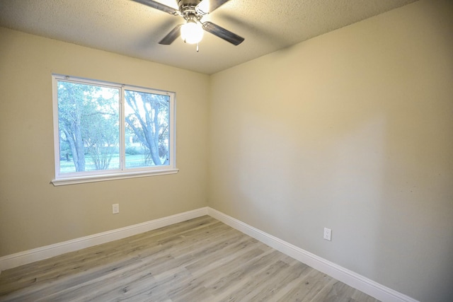 empty room featuring ceiling fan, light hardwood / wood-style floors, and a textured ceiling